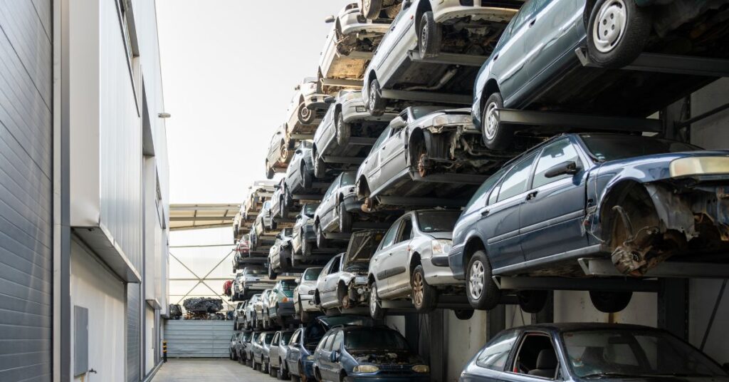 Rows of dismantled vehicles stored on racks at a car wrecking and auto recycling facility.